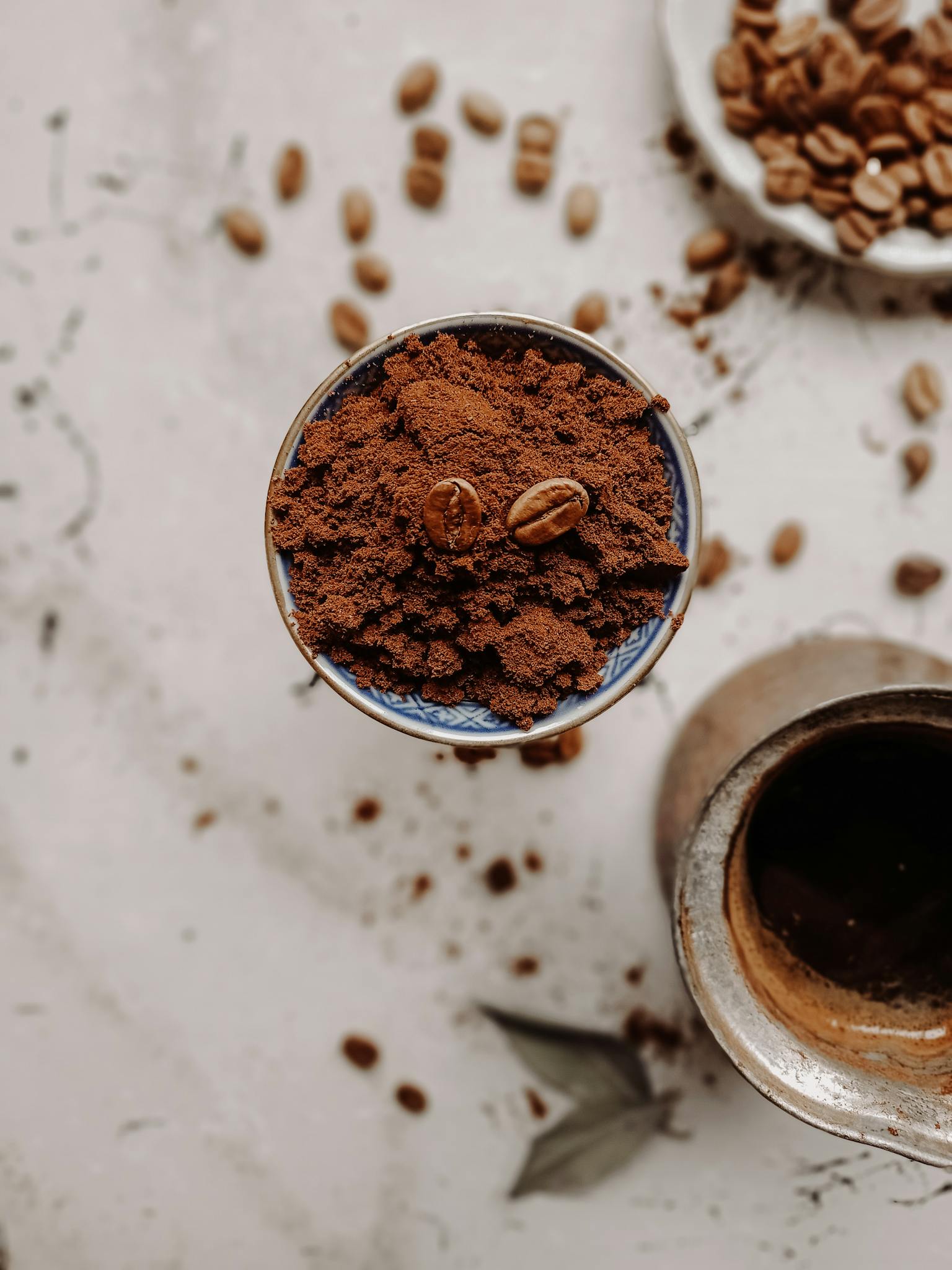 Aerial shot of ground coffee in a bowl with beans spilled, captured in Turkey, showcasing the essence of coffee.